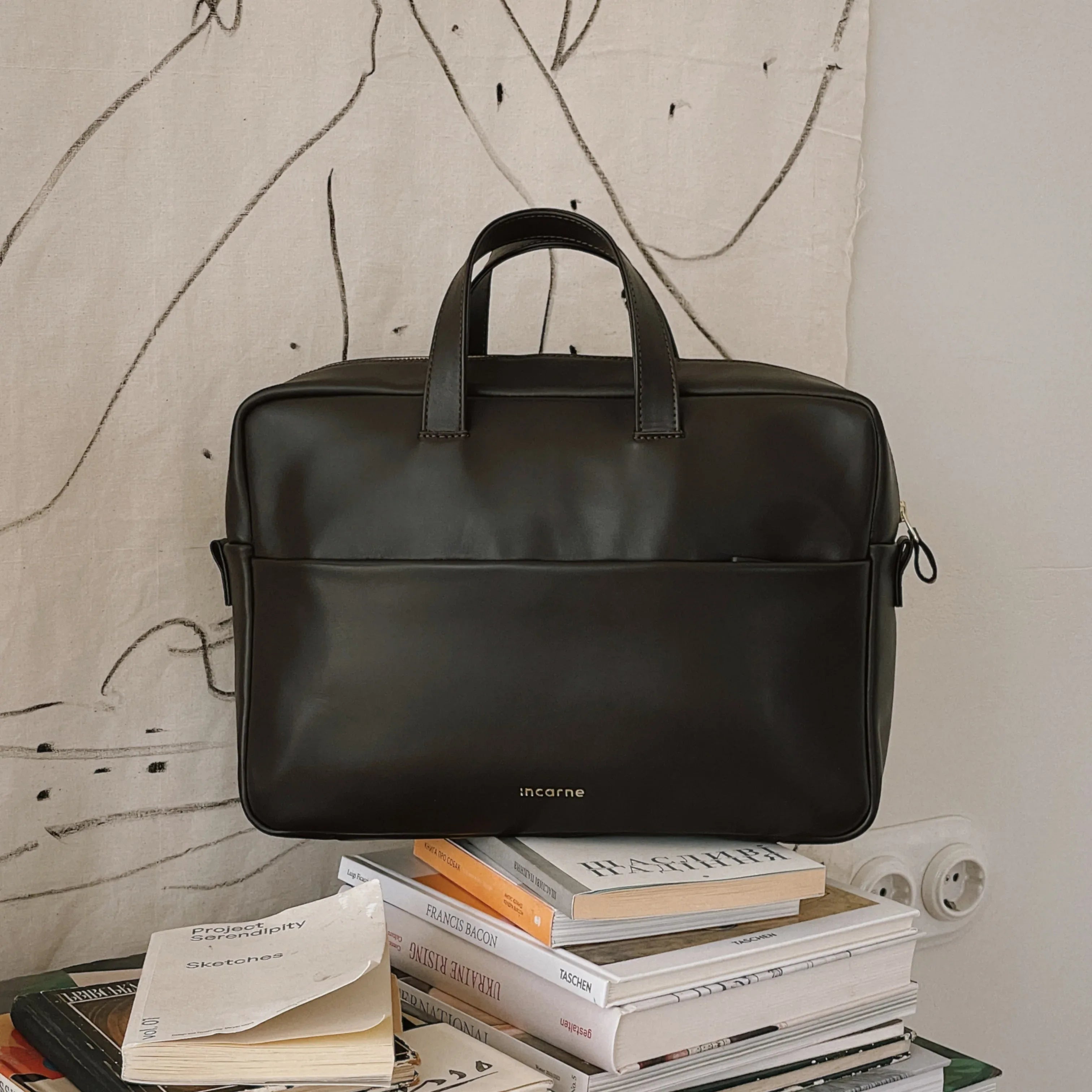 Ділова шкіряна сумка Brief шоколадного кольору на фоні валізи, варіант для подорожей