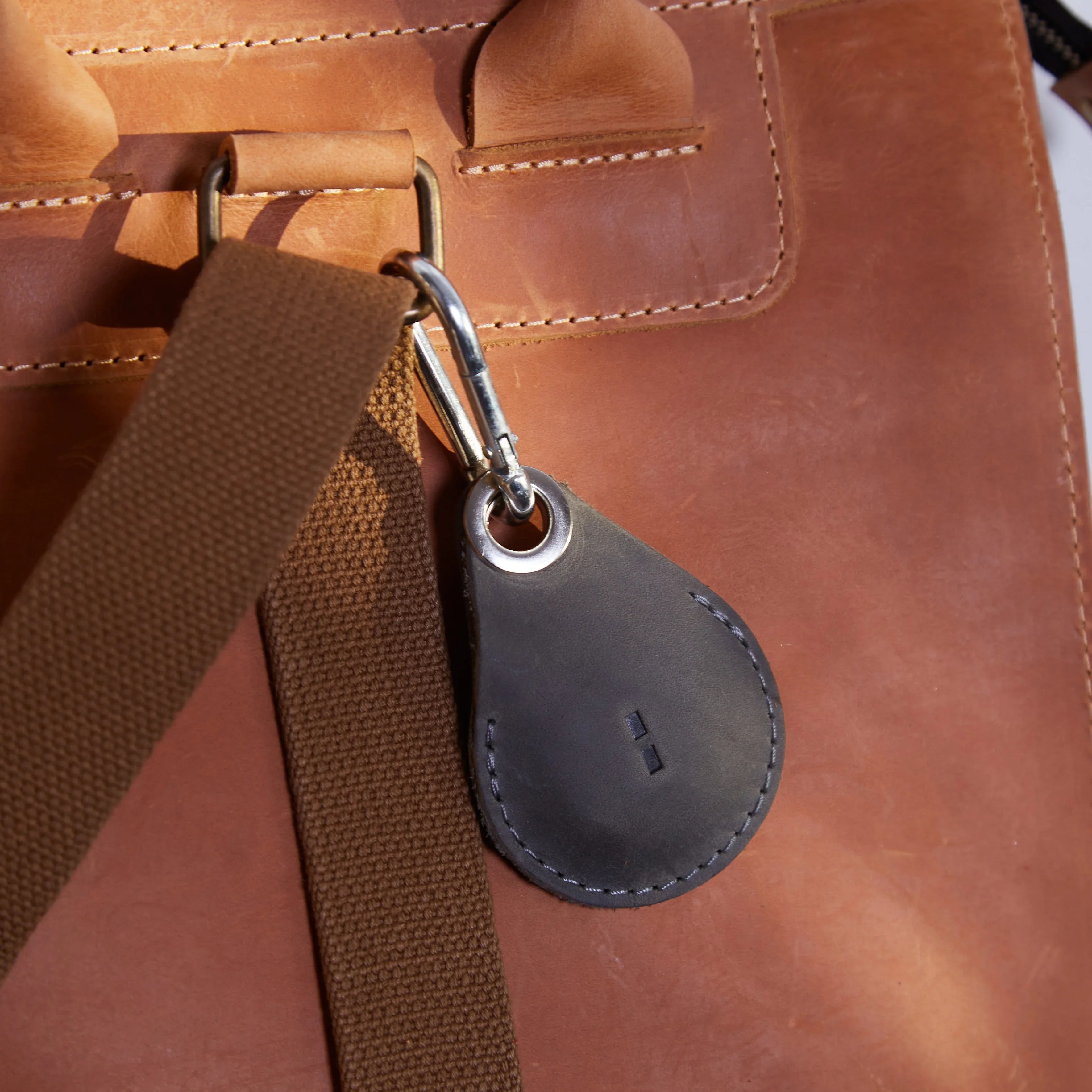 Сірий шкіряний AirTag Key Tag, прикріплений до ключів, як аксесуар для щоденного використання і подорожей