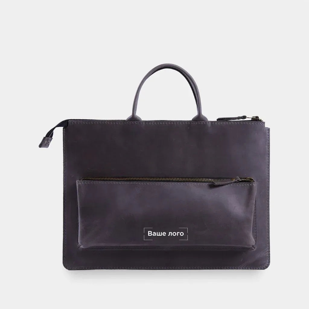 Шкіряний чохол для ноутбука Maryland від INCARNE на столі, вигляд спереду з ручками та передньою кишенею